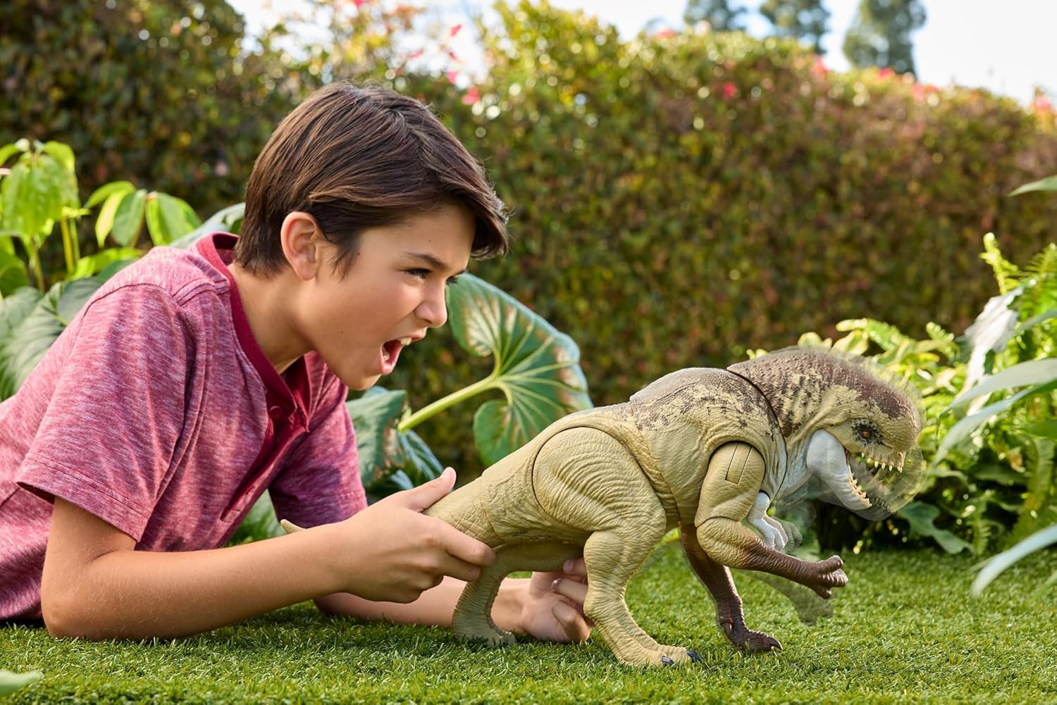 Child playing with toy dinosaurs on grass