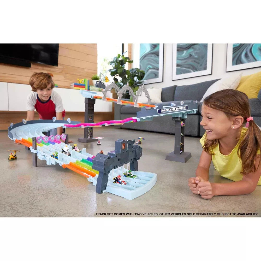 Children playing with a toy race track set in a living room.